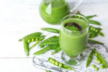 Healthy green smoothie on wooden table, closeup