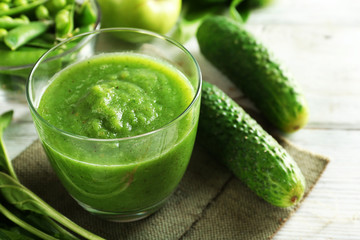 Healthy green smoothie on wooden table, closeup