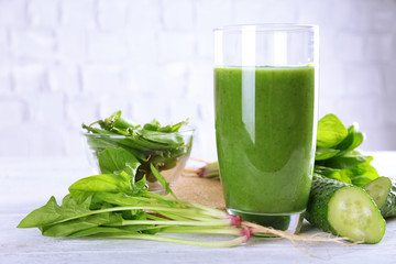 Healthy green smoothie on wooden table on white wall background