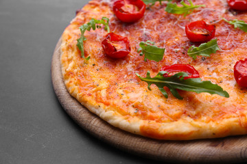 Pizza with arugula and cherry tomatoes on wooden table, closeup
