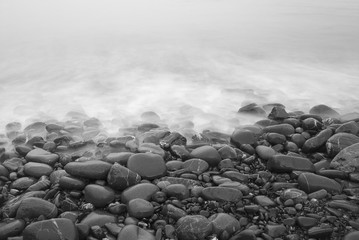 Evening tide on the beach with stones in a long exposure