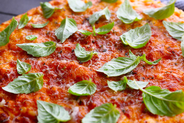 Pizza with green leaves , closeup