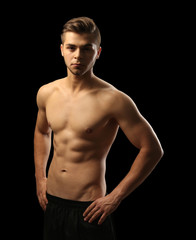Fototapeta premium Muscle young man on dark background