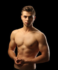 Fototapeta premium Muscle young man on dark background
