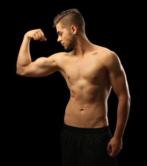 Fototapeta premium Muscle young man on dark background