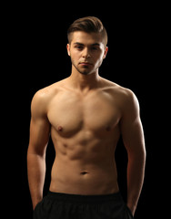 Fototapeta premium Muscle young man on dark background