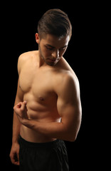 Fototapeta premium Muscle young man on dark background