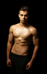 Fototapeta premium Muscle young man on dark background