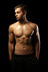 Fototapeta premium Muscle young man on dark background