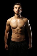Fototapeta premium Muscle young man on dark background