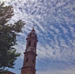 campanile con cielo pieno di muvolette