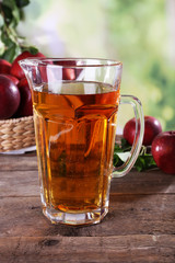 Full jug of apple juice and fruits on bright background