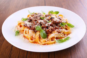 Pasta Bolognese with parmesan and basil on table close up