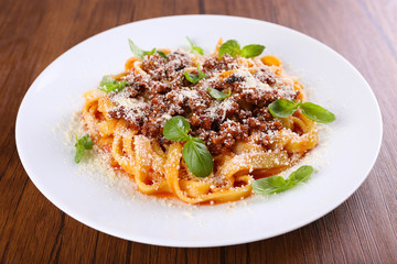 Pasta Bolognese with parmesan and basil on table close up