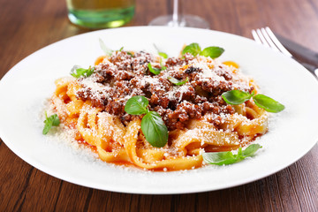 Pasta Bolognese with parmesan and basil on table close up