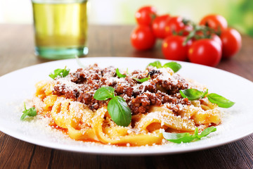 Pasta Bolognese with parmesan and basil on table close up