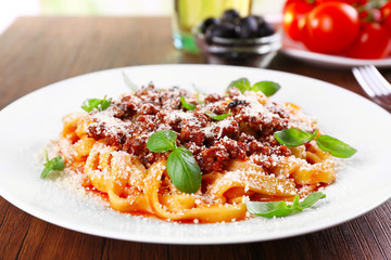 Pasta Bolognese with parmesan and basil on table close up