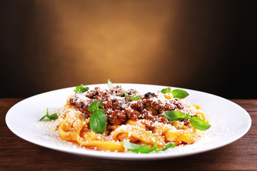 Pasta Bolognese with parmesan and basil on dark background