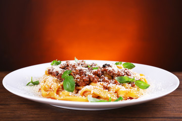 Pasta Bolognese with parmesan and basil on dark background