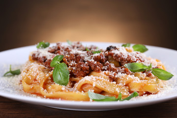 Pasta Bolognese with parmesan and basil on dark background