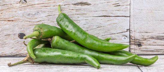 Chili peppers over wooden background