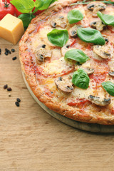 Tasty pizza with vegetables and basil on table close up