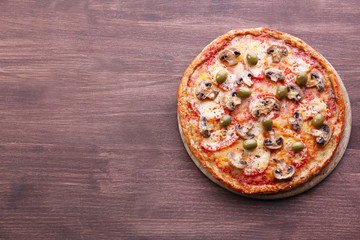 Tasty pizza with vegetables on wooden background