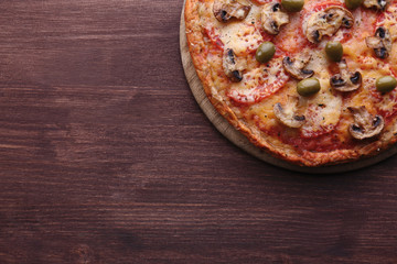 Tasty pizza with vegetables on wooden background