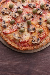 Tasty pizza with vegetables on wooden background