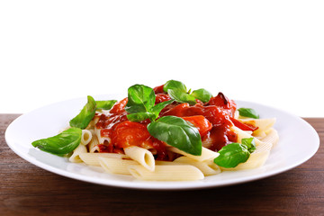 Pasta with tomato sauce and basil on light background