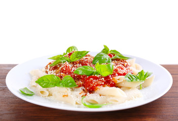 Pasta with tomato sauce and basil on light background