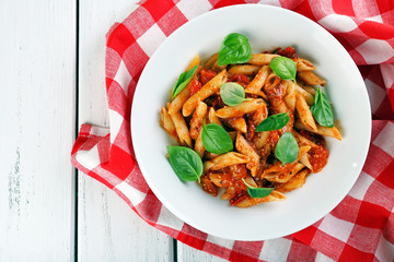 Pasta with tomato sauce and basil on table close up
