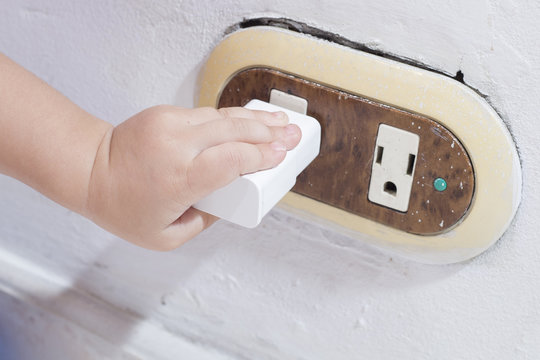 Mano de ni&ntilde;o en tomacorriente, peligro
