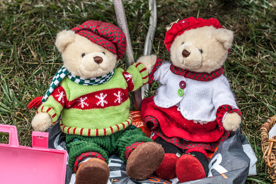 display of a couple of second hand teddy bears dressed up for winter or Christmas time with home-made knitwear sold at garage sale for antique collection
