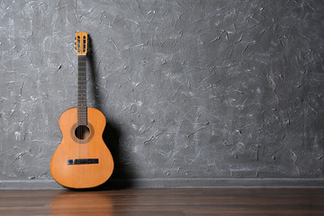 Classical acoustic guitar on gray wall background