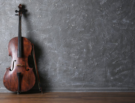 Classical cello and bow on gray wall background
