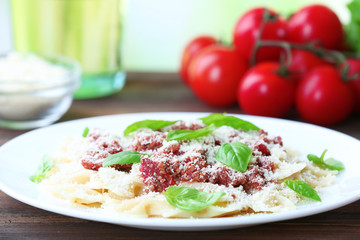 Pasta bolognese in white plate on wooden table, closeup