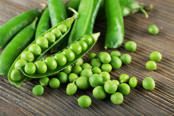 Fresh green peas on wooden table, closeup