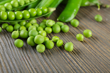 Fresh green peas on wooden table, closeup