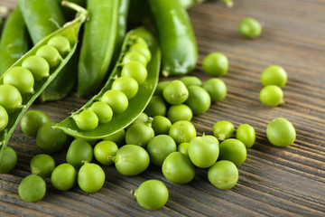 Fresh green peas on wooden table, closeup