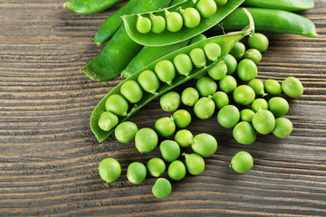 Fresh green peas on wooden table, closeup