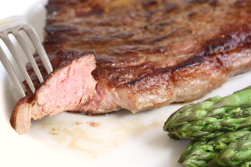 served delicious piece of medium grilled beef steak with asparagus
