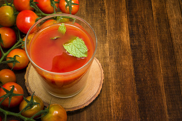 Glass of tomato juice on wooden table