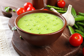 Tasty peas soup and vegetables on table close up
