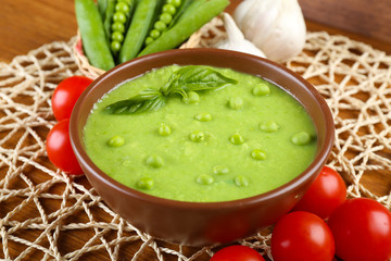 Tasty peas soup and vegetables on table close up