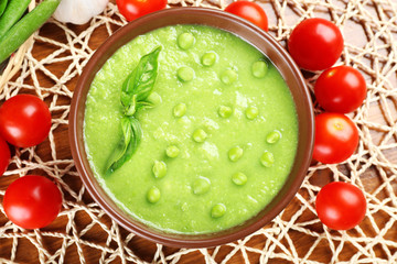 Tasty peas soup and vegetables on table close up