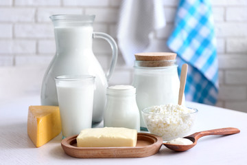 Dairy products on wooden table, on brick wall background