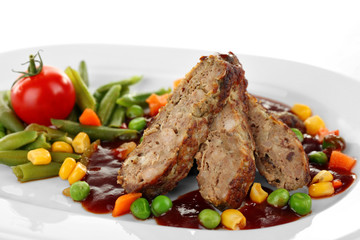 Tasty slices of meat with vegetables on plate close up