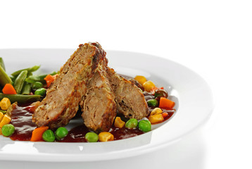 Tasty slices of meat with vegetables on plate isolated on white