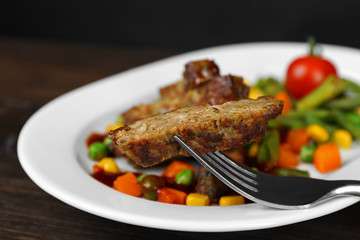 Tasty slices of meat with vegetables on table close up